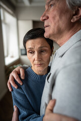Senior woman in husband embrace comforting thoughtful sad mood. Marital support in hardships,...