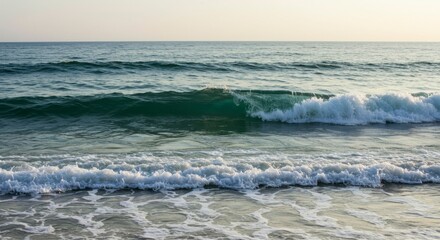 Serene ocean waves gently rolling onto a sandy shore at sunset, creating a peaceful and tranquil scene