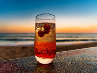 A collection of Italian soda beverages with colorful layers and fruit garnishes at sunset