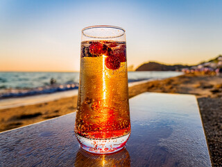 Italian soda drinks with strawberries and lemon slices photographed in front of ocean views