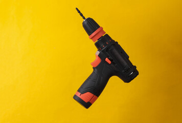 Cordless screwdriver isolated on yellow background