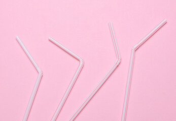 Set of plastic straws on a pink background