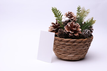 Christmas decor. Composition with pine cones in a wicker basket on a white background