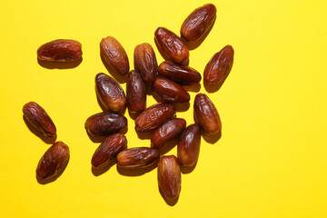 Dry tasty dates on yellow background