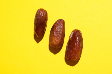 Dry tasty dates on yellow background