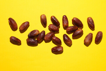 Dry tasty dates on yellow background