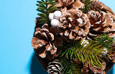 Christmas decor. Composition with pine cones in basket on blue background. Top view