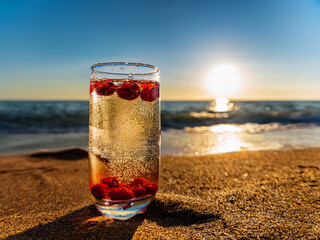 Italian soda drinks with strawberries and citrus photographed at the beach during sunset