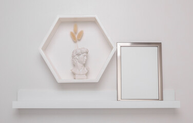 Shelf with empty photo frame and wall decor. Mockup for design
