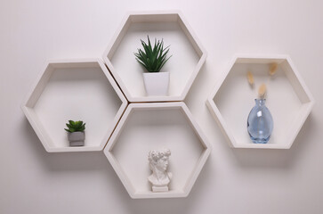 Hexagonal honeycomb shelves with decor on white background. Wall decoration