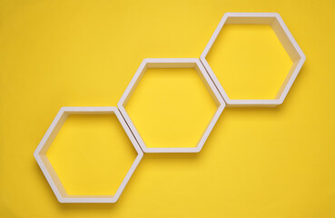 Hexagonal honeycomb wall shelves on yellow background