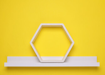 White hexagonal and straight wall shelves on yellow background