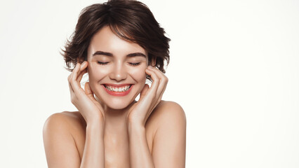 Beauty and wellness. Happy woman with candid, cheerful emotions, touches her face and laughs, has glowing, radiant skin without blemishes, natural glow of skin, white background