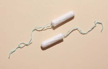 Tampons for feminine intimate hygiene on a beige background. Menstruation, critical days, female...