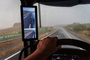 View from the driver's seat of a truck, windshield covered with raindrops during heavy rain.