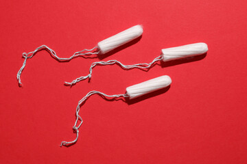 Tampons for feminine intimate hygiene on red background. Menstruation, critical days, female cycle