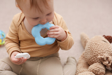 Little cute baby gnaws circle of pyramid sitting on the floor
