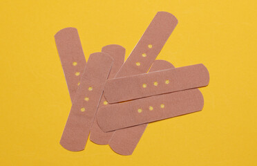 Medical Adhesive bandage plasters on yellow background