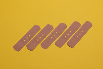 Medical Adhesive bandage plasters on yellow background