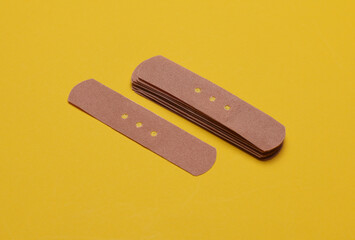 Medical Adhesive bandage plasters on yellow background