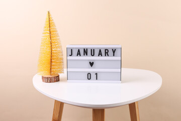 Lightbox calendar with date january 01 on table with christmas decorative tree. Holiday concept