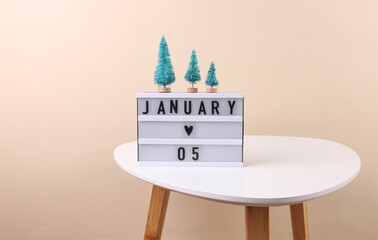 Lightbox calendar with date january 05 on table with christmas decorative tree. Holiday concept
