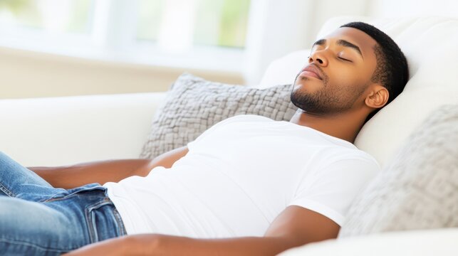 Restful Slumber: A portrait of serenity, featuring a young man lost in tranquil sleep on a comfortable sofa, embodying peace and relaxation.