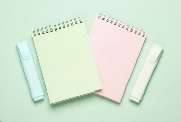 Markers or colored felt-tip pens with notebooks on pastel background. Creative layout. Top view
