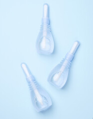 Three vaginal enemas on a blue background. Women's health