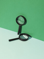 Magnifying glasses on green background with shadow. Creative layout. Minimal business concept....