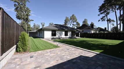 Stylish modern home featuring a paved driveway and fenced entrance with contemporary design elements.