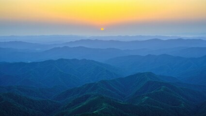 Obraz premium Golden sunrise over blue mountain layers mountains