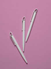 White pens on a pink background
