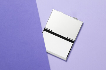 Metal box business card holder with business cards on a purple background