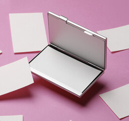 Metal box business card holder with business cards on pink background