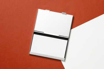 Metal box business card holder with business cards on red white background