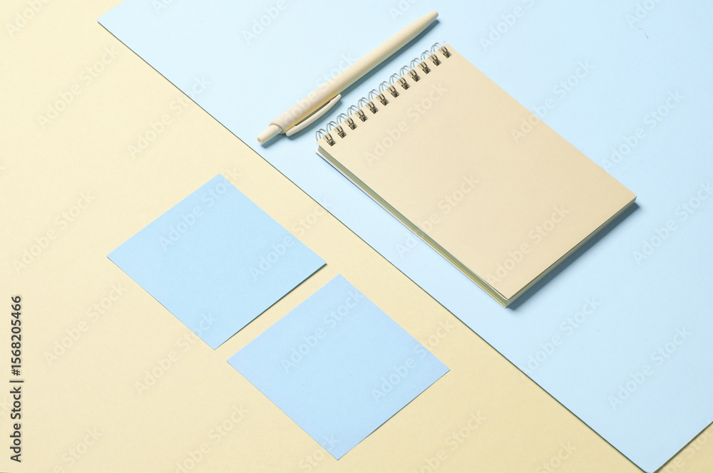 Fototapete notebook with memo papers, pen on a blue-yellow pastel background. creative layout