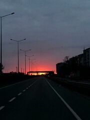 Open Road Sunset: A lone road vanishing into the distance beneath a dramatic sunset, the scene...