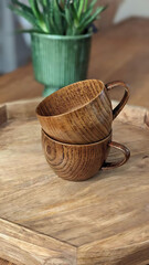The cups are a rich, warm brown color, with visible wood grain.