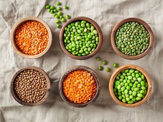 Various legumes displayed in wooden bowls on a linen background  