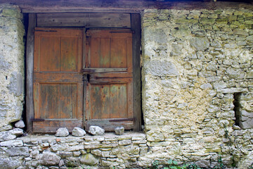 old stone wall with window with shutters