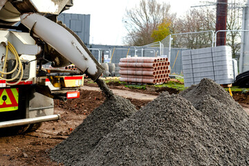 Semy-dry ready mix concrete delivered on construction site and unloaded into pile on ground
