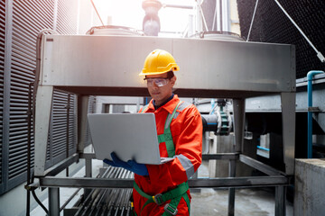 A man in a red and orange jumpsuit is looking at a laptop computer