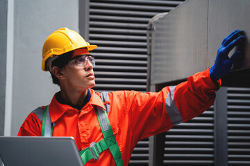 A man in a safety vest is looking at a laptop