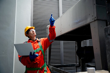 A man in a red jacket is pointing at a piece of equipment