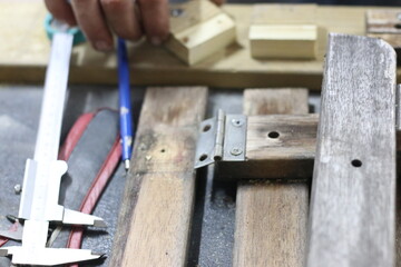 Carpenter making a table from recycled wood with a hinge