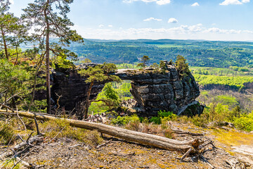 A view from a rocky viewpoint towards the Pravcicka Gate arch and surrounding countryside in...