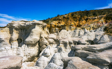 Jagged spires of pink and yellow sandstone rise toward the sky at the Painted Mines, showcasing...