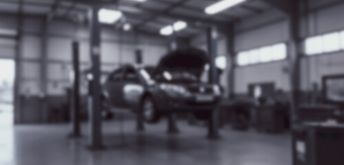 Obraz premium Car on lift in auto repair shop with hood open for maintenance.