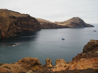 Desert landscapes of Cape Sao Lourenco. Colourful hills and a boat in a calm bay. Nature of Madeira...